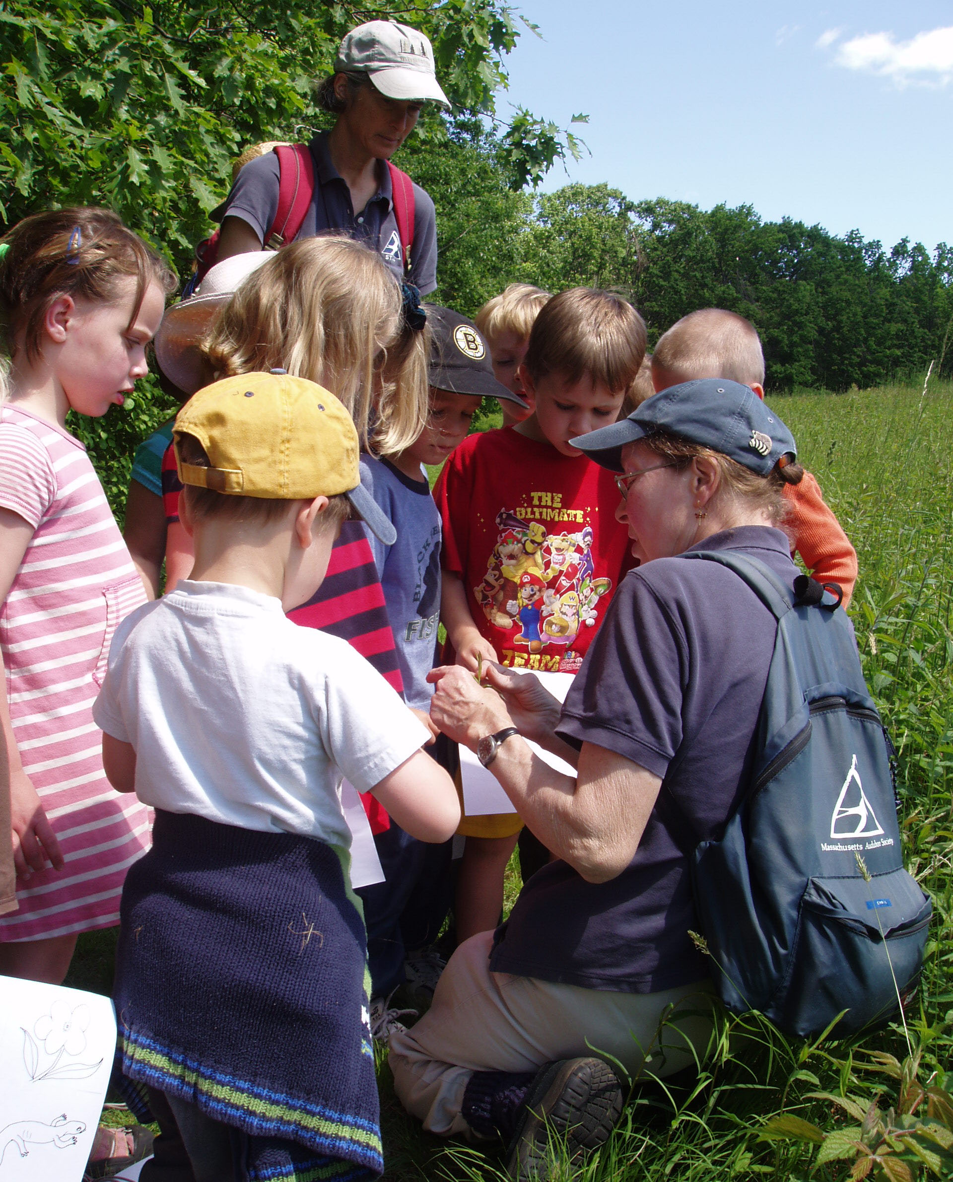 Counselors and campers examining nature object